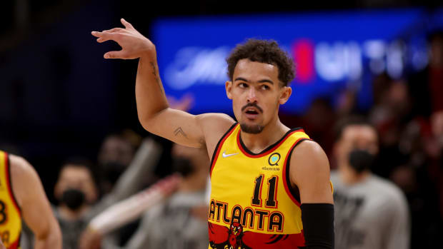 Trae Young holds his follow-through after making a shot.